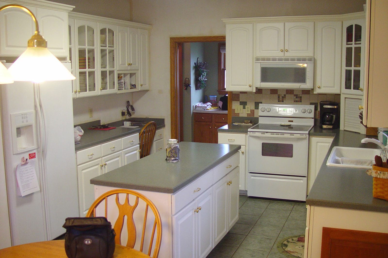 old painted white kitchen before kitchen refacing with center island and the cabinet does not extend to the ceiling