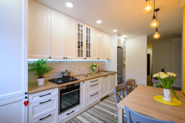 beautiful white kitchen cabinet with long countertops and lights.