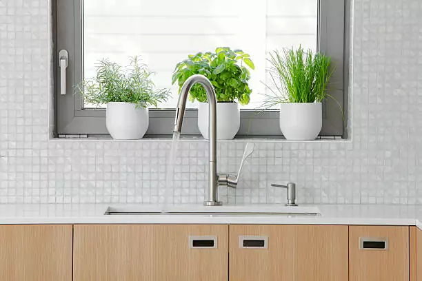 Modern kitchen with a sink and faucet near the kitchen's window.