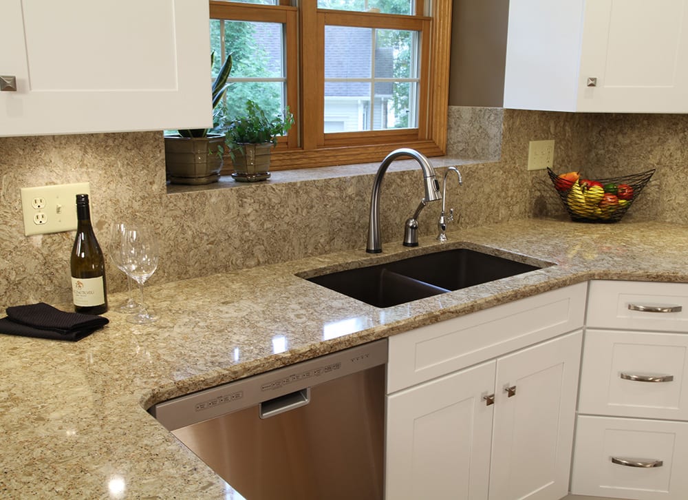 Kitchen cabinet refacing with new countertop and backsplash, featuring sink and faucet.