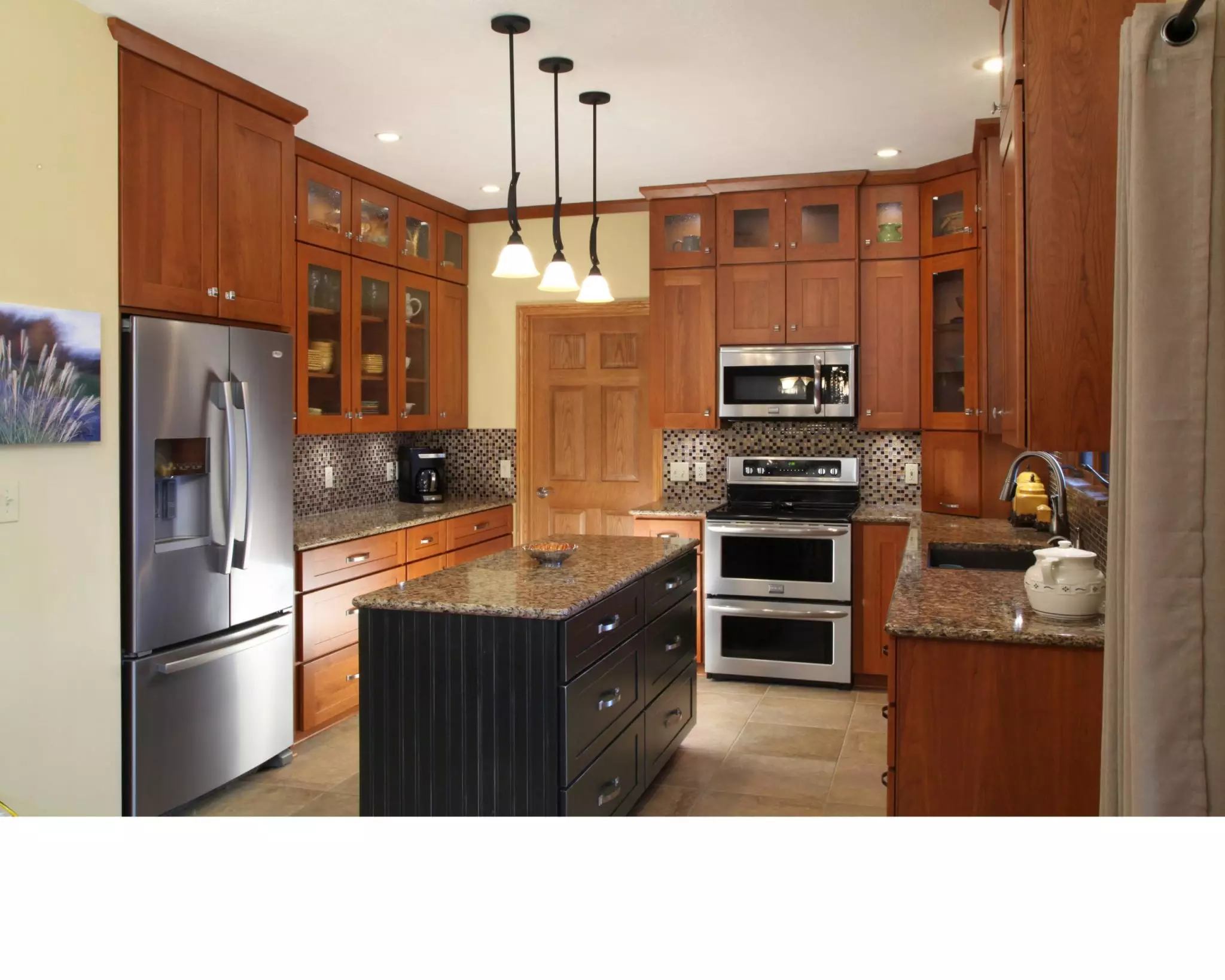 Refaced kitchen cabinets with new lighting and a kitchen island