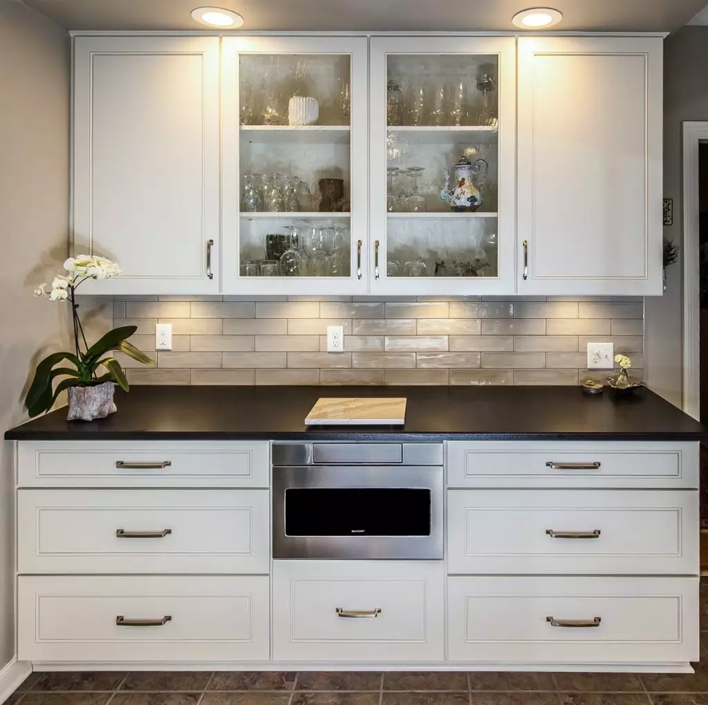 A set of white kitchen cabinets with a black countertop