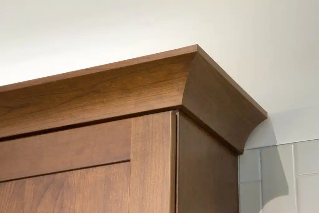 Cove crown molding on kitchen cabinets with a warm wood finish