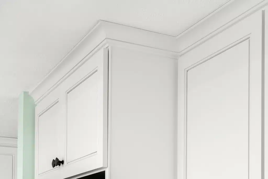 White crown molding on refaced upper kitchen cabinets where they meet the ceiling