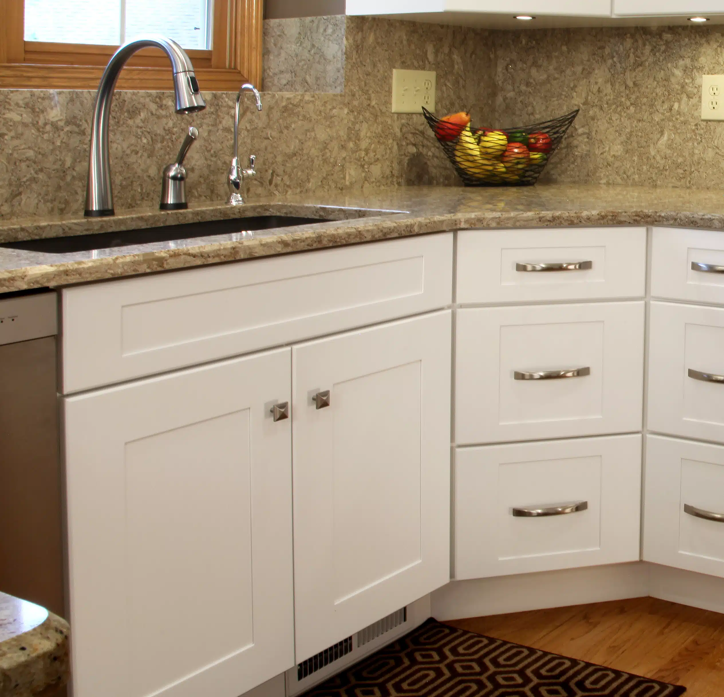Clean kitchen cabinets being wiped down with a household cleaner for routine maintenance