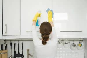 Cleaner using the liquid soap to clean the cabaniet doors in the kitchen