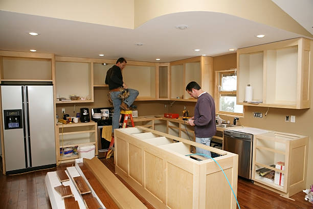 Cabinet maker installing custom made kitchen cabinet reface.