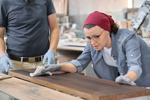 craftswoman assessing durability of wood for cabinet refacing